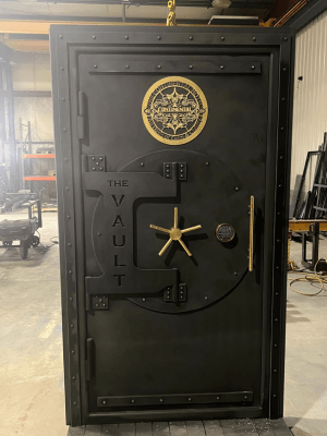 black battleship vault door with a custom gold logo. (1)