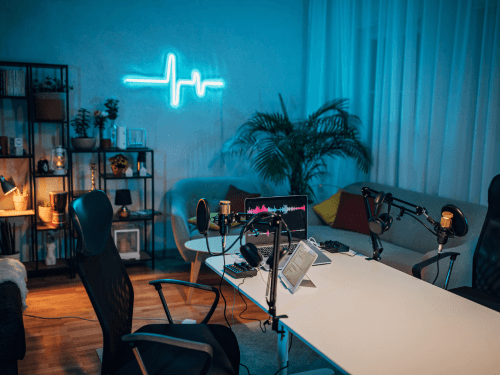 a home podcast studio with a table, chairs, sofa, and mic.